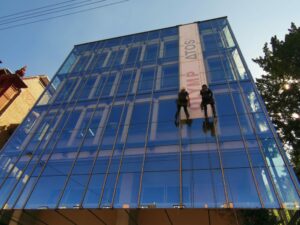 Höhenarbeiten, Bannerinstallation an Glasfassade, Industrieklettern Werbeanbringung ohne Hebebühne oder Gerüst